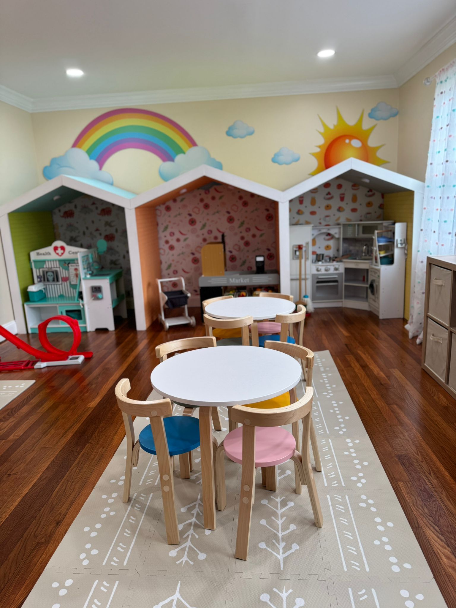 Colorful play area with house structures and rainbow mural
